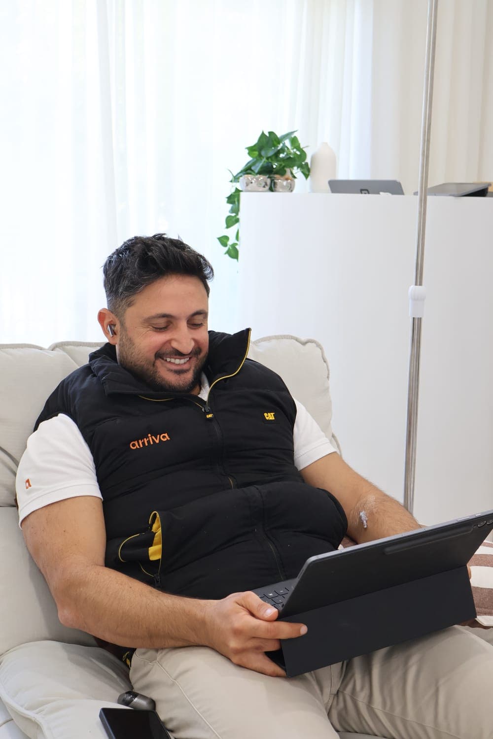 A client working on his laptop while receiving an IV drip at IVION Health