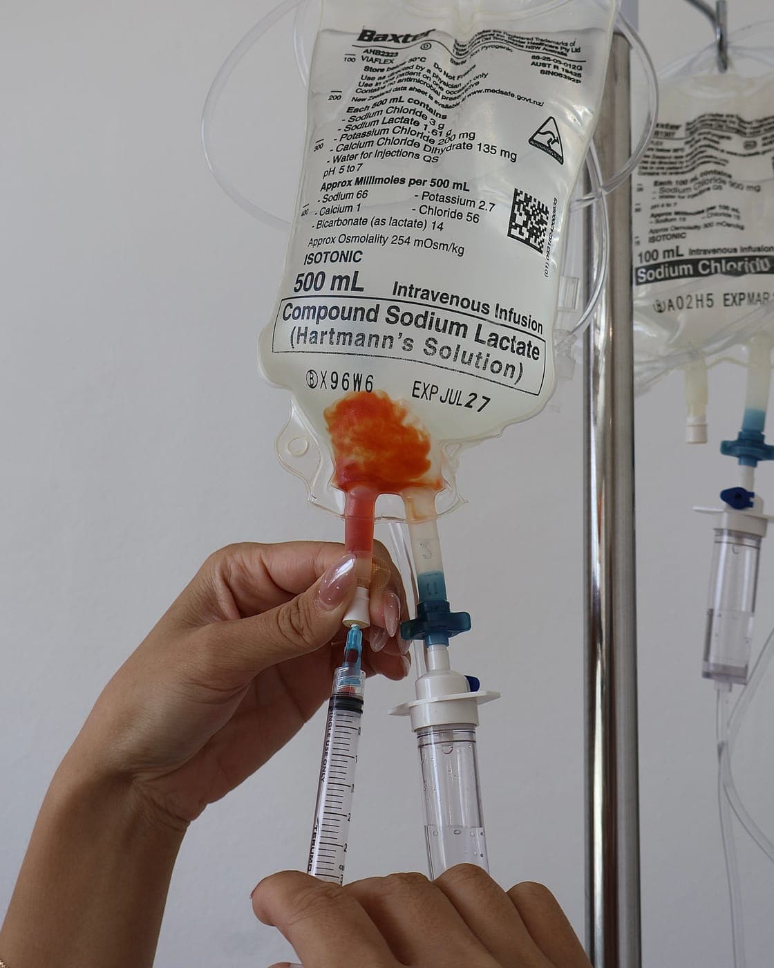 A registered nurse preparing a fresh IV drip by hand at IVION Health